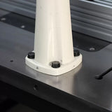 Close-up of a metal machine base secured with bolts on a woodworking table