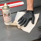 Hand in black nitrile glove cleaning table saw with cloth and rust protection spray