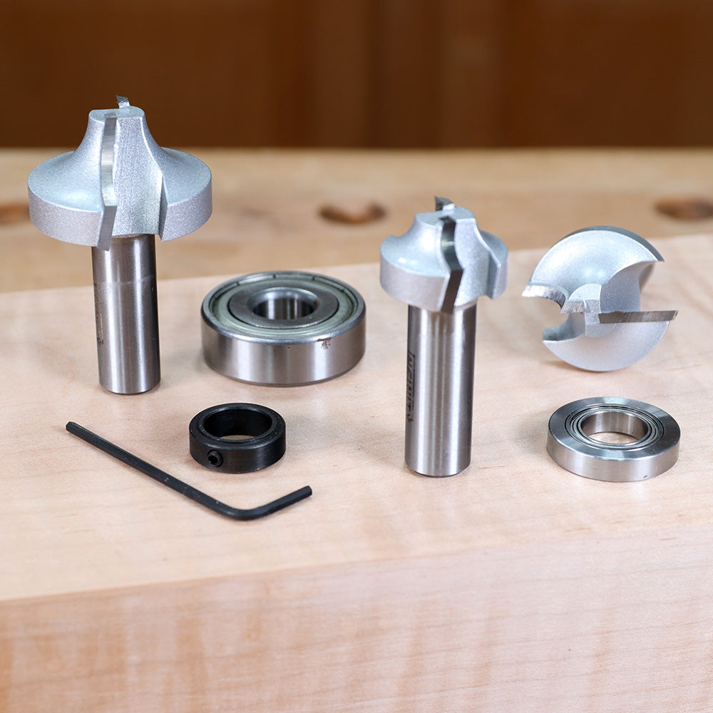 Woodworking router bit set with bearings and hex key on a wooden workbench