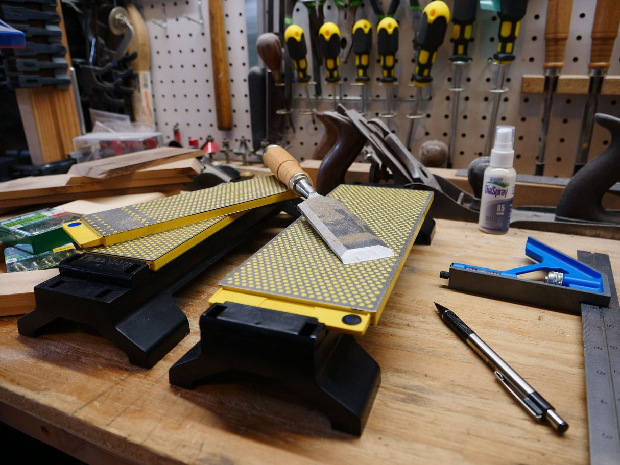 Woodworking bench with sharpening stones, hand plane, chisel, screwdrivers, and tools
