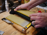 Sharpening a woodworking chisel on a diamond sharpening stone in a workshop