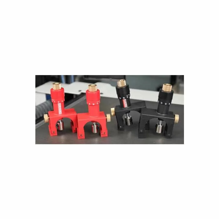 Precision woodworking router lift mechanisms in red and black on a workshop table