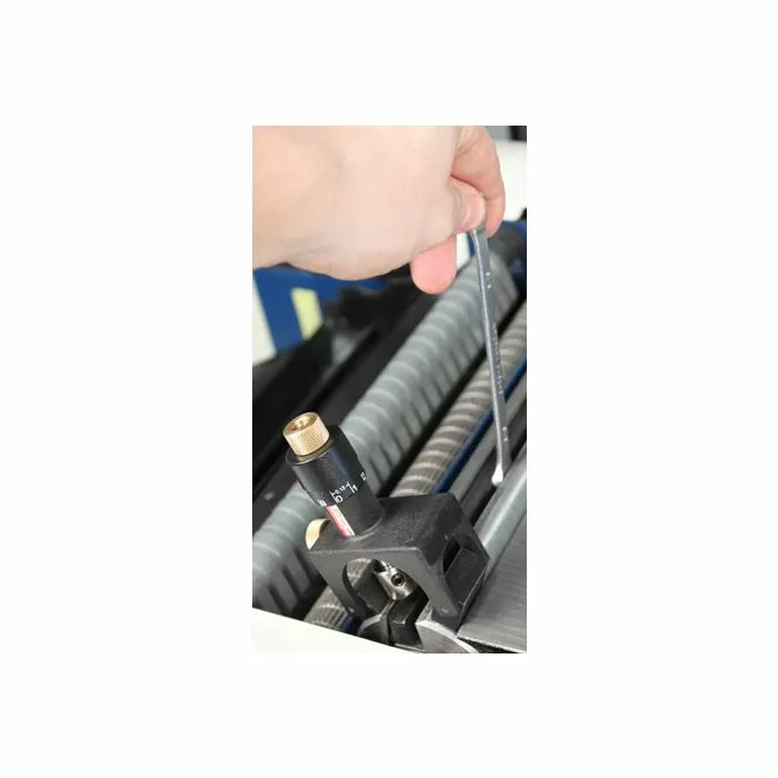Hand adjusting woodworking planer gauge on jointer cutterhead with hex key