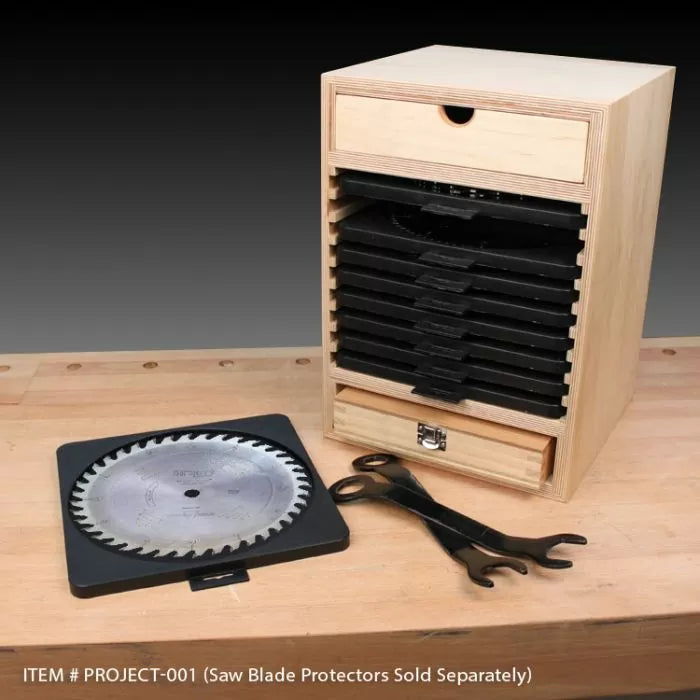 Wood saw blade storage cabinet with multiple slots, drawer, saw blade, and wrenches on a workbench.