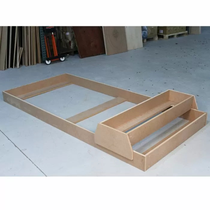 Unfinished MDF workbench base and shelves on workshop floor for woodworking projects