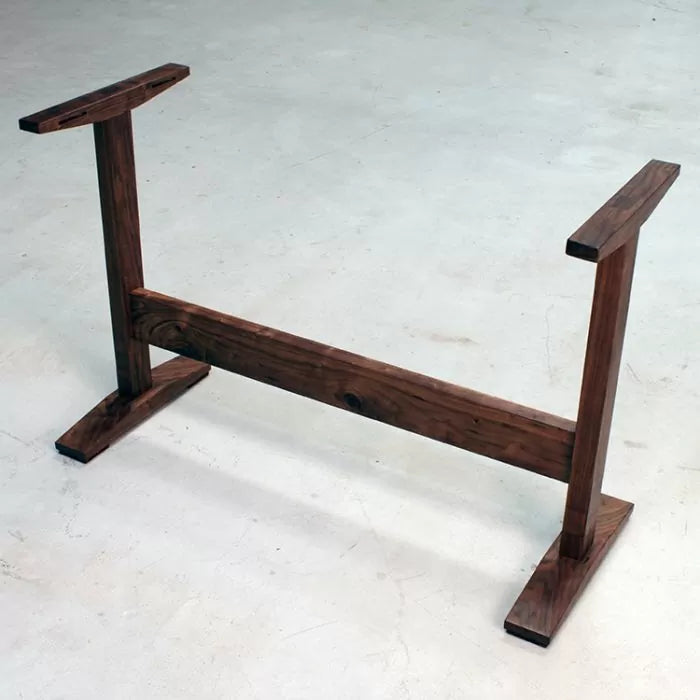 Wooden table base frame on a light workshop floor, ideal for woodworking projects.
