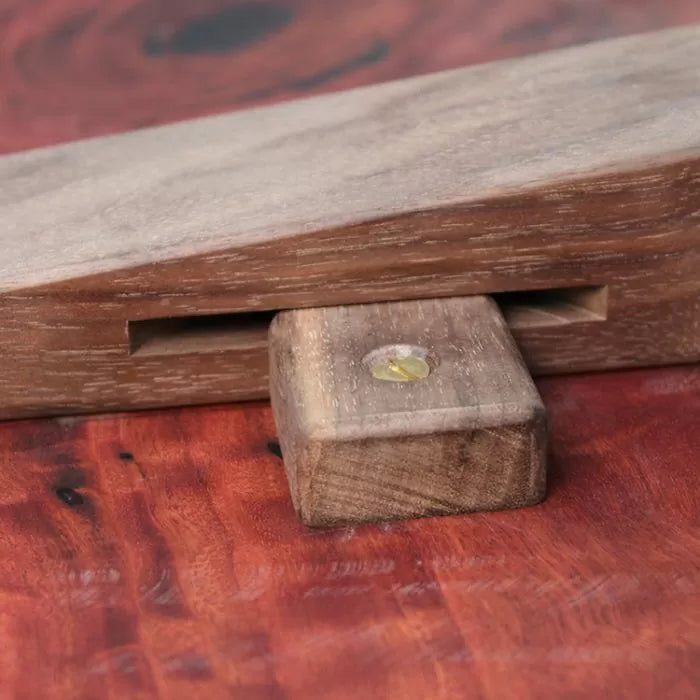 Close-up of a wooden wedge and block clamping system on a finished wood surface