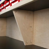 Wood shelf bracket with pocket hole joinery supporting a plywood workbench shelf