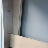Close-up of plywood cabinet joint with pocket holes for woodworking assembly