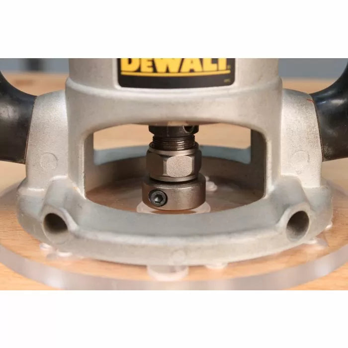 Close-up of a woodworking router base showing router bit and adjustment nut on a wood surface