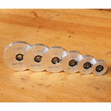 Set of six aluminum router bit setup gauges in graduated sizes on a wooden workbench