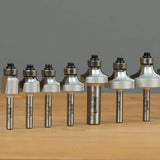 Set of varying roundover router bits on a wooden surface for woodworking.