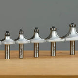 Set of roundover router bits with ball bearings on wooden surface, woodworking tools