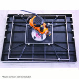 Router table top with mounting plate, shown with an orange handheld router for woodworking.