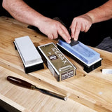 Sharpening woodworking chisel with Cerax honing stones on a wooden workbench