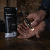 Person using illuminated tweezers from sliver removal first aid kit on hand, med pack nearby