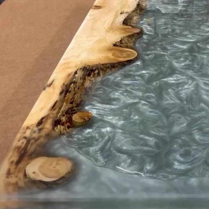 Live edge wooden slab with glossy resin river effect, woodworking table close-up