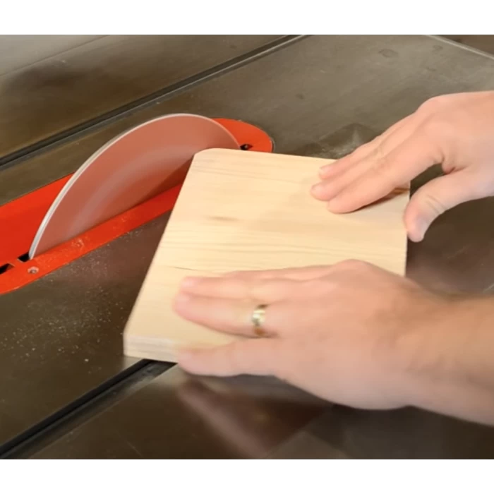 Cutting a wooden board with a table saw for woodworking precision