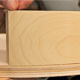 Close-up of a cleanly cut wooden block on layered wood, precision woodworking detail