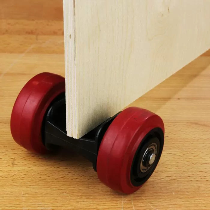 Panel carrier with red wheels holding a wood board on a workshop surface
