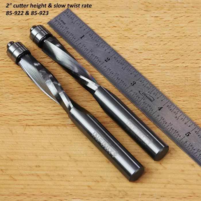 Two spiral flush trim router bits with slow twist rate beside a ruler on a woodworking table.
