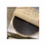 Hand holding sandpaper over a round sanding disc for woodworking surface preparation
