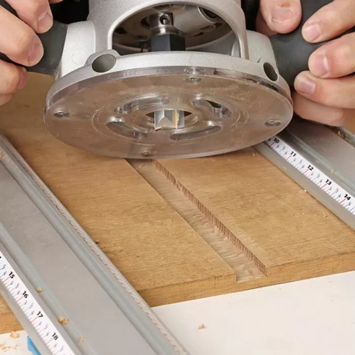 Straight router bit cutting groove in wood with handheld router, woodworking tools in use