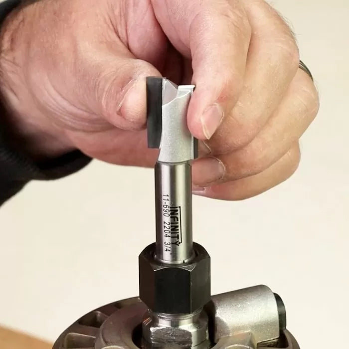 Hand installing straight router bit into router collet for woodworking tool setup