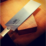 Japanese ryoba saw with fine teeth on a wood block, woodworking tool for precise cutting