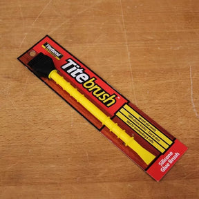 Titebrush silicone glue brush in packaging on wooden surface, ideal for woodworking projects
