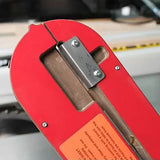 Table saw insert with steel hinge and safety label in a woodworking workshop setting