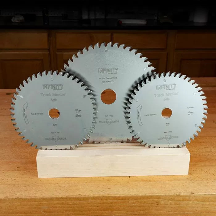 Three circular saw blades for woodworking displayed on a wooden workbench.