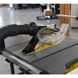 Table saw with dust collection hose and clear blade guard in a woodworking shop