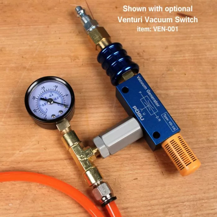 Vacuum generator with pressure gauge and orange hose on a wood surface for woodworking tools