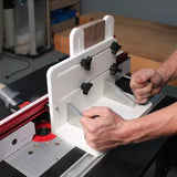 Woodworker using a tenoning jig for precise cuts on a router table setup.