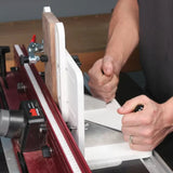 Woodworker using router table fence system for precise edge routing on wood