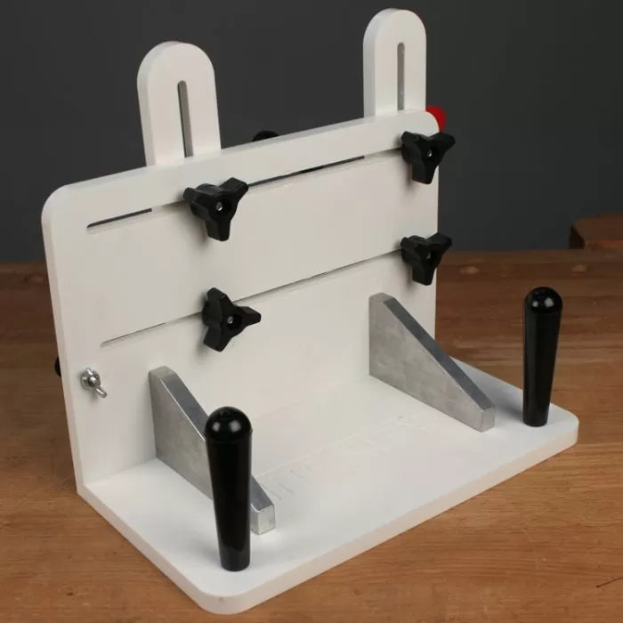 Woodworking jig with adjustable knobs and aluminum guides on workbench