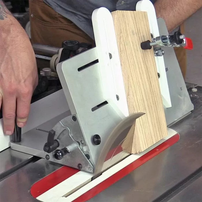 Woodworker using table saw with a safety jig to cut angled wood piece